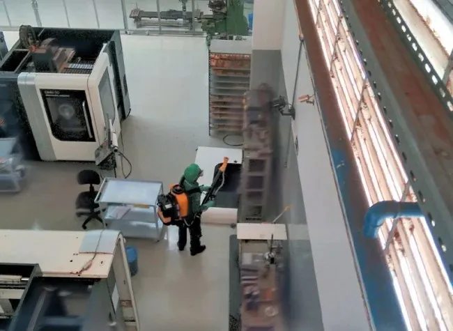 Técnico nebulizando o interior de um galpão